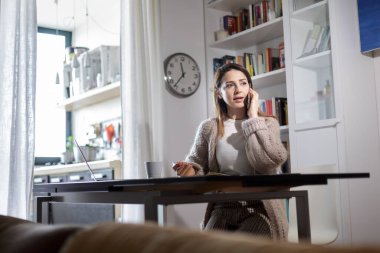 Esmer kız evdeki bilgisayarda çalışıyor.