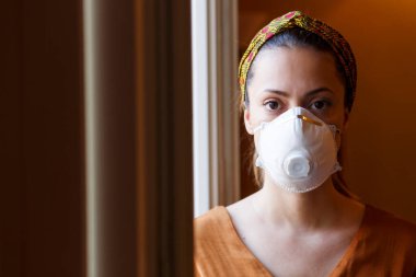 Evde maskeli bir kadın var. Koronavirüs salgını