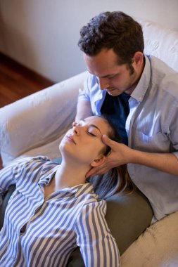 Çift oturma odasında masaj yaptırıyor.