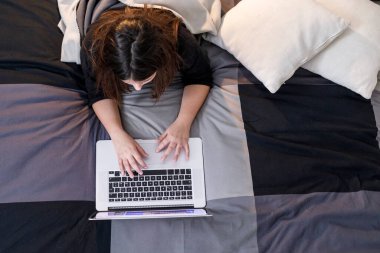 Siyah saçlı genç kız defteriyle sohbet ediyor.