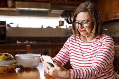 Evinde rahat olan yaşlı bir kadının portresi.