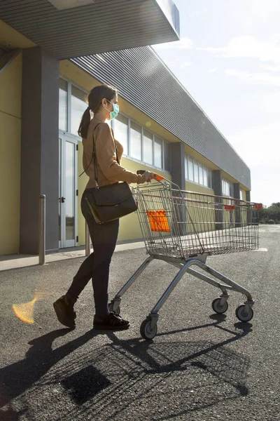 Meisje Met Oranje Trui Jeans Gezichtsmasker Wandelingen Met Het Winkelwagentje — Stockfoto