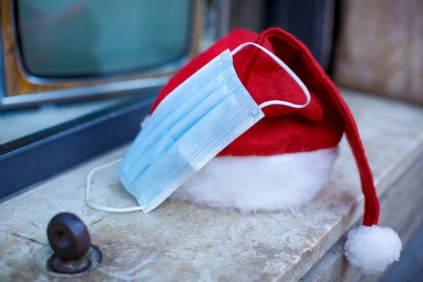 Nikolausmütze Mit Chirurgenmaske Der Nähe Und Hintergrund Hinter Einem Schaufenster — Stockfoto