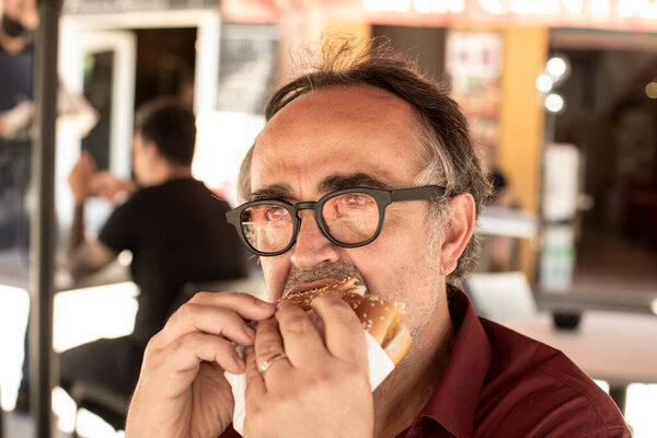 man eating a sandwich in the street