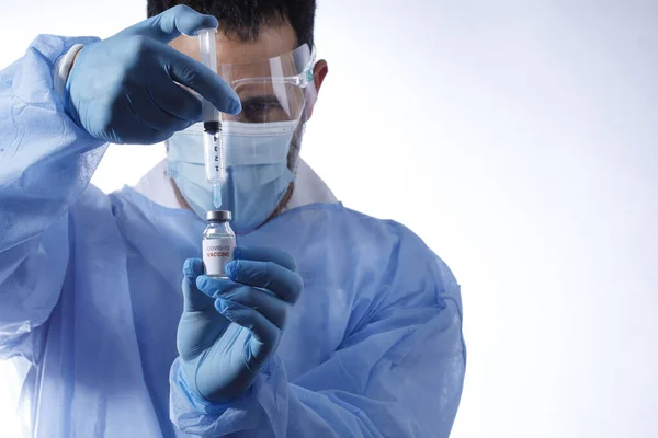 带着外科口罩和乳胶手套的医生从一个白色背景的玻璃瓶中取出了抗弧菌疫苗 — 图库照片