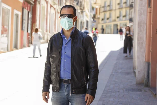 マスクをした普段着姿の男が外科用マスクで街を歩く — ストック写真