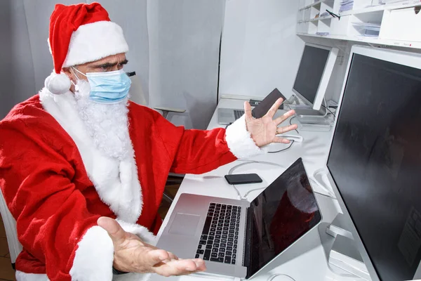 Santa Claus Con Una Máscara Quirúrgica Sentado Oficina Utiliza Computadora —  Fotos de Stock