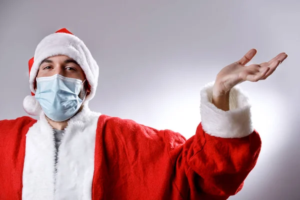 Jovem Santa Claus Vestindo Máscara Protetora Rosto Espalha Suas Mãos — Fotografia de Stock