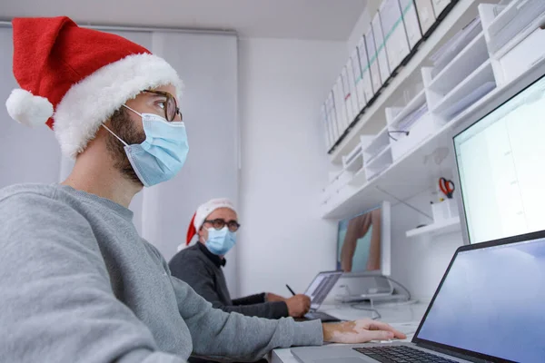 Мужчины Медицинских Масках Работающие Офисе Ноутбуками Рождественская Концепция Новый Год — стоковое фото