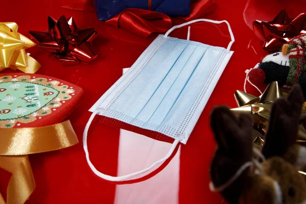 Sebészeti Maszk Közepén Sok Karácsonyi Elemek Dekorációk Egy Piros Asztalon — Stock Fotó