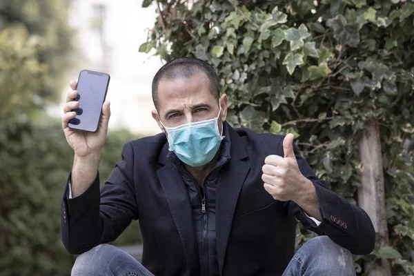 Shaved Man Jacket Wears Protective Mask Shows Screen Black Mobile — Stock Photo, Image