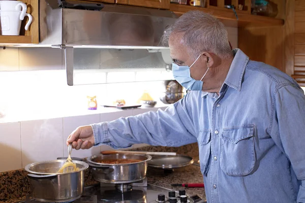 stock image senior man making soup with pasta