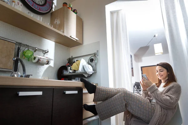 Rahat Giyimli Kız Cep Telefonuna Bakarken Mutfakta Rahatça Oturuyor — Stok fotoğraf