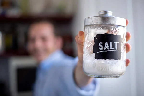 Hvit Mann Viser Krukken Med Salt Mens Han Tilbereder Lunsj – stockfoto