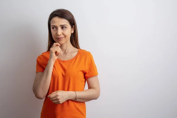 Brunett Flicka Med Orange Skjorta Tveksam Isolerad Vit Bakgrund — Stockfoto