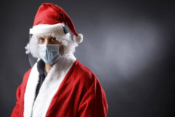 Der Weihnachtsmann Mit Chirurgenmaske Plexiglas Schutzschild Und Weihnachtsmütze Sieht Ernst — Stockfoto