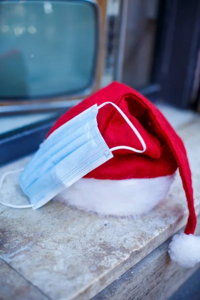 Santa Claus Hatt Med Kirurgisk Mask Närheten Och Bakgrunden Bakom — Stockfoto