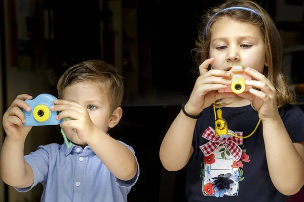 Двое Маленьких Детей Играют Цветными Фотоаппаратами — стоковое фото