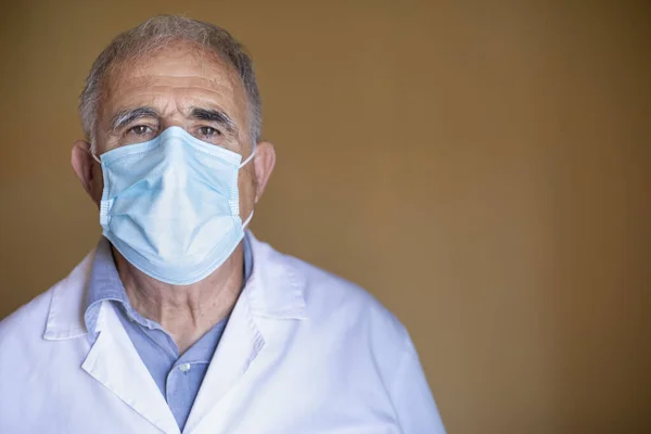 Lähikuva Komea Lääkäri Valkoisessa Naamiossa Katselee Kameraa Valkoisella Taustalla Terveydenhuollon — kuvapankkivalokuva