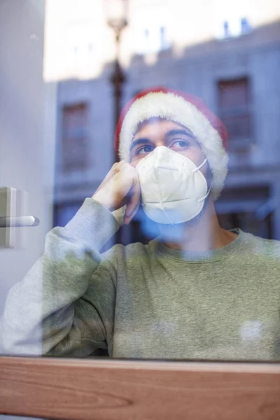 Man Face Mask Christmas Hat Looking Window — Stock Photo, Image