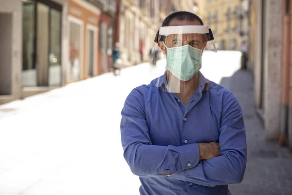 市内中心部に青いシャツの顔のマスクとプレキシガラスのスクリーンを持つ男 — ストック写真