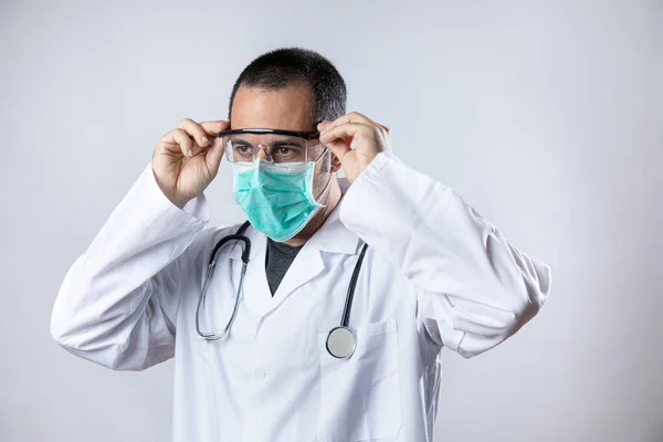외투를 청진기를 두르고 의사는 수술용 마스크를 배경에 외따로 안경을 — 스톡 사진