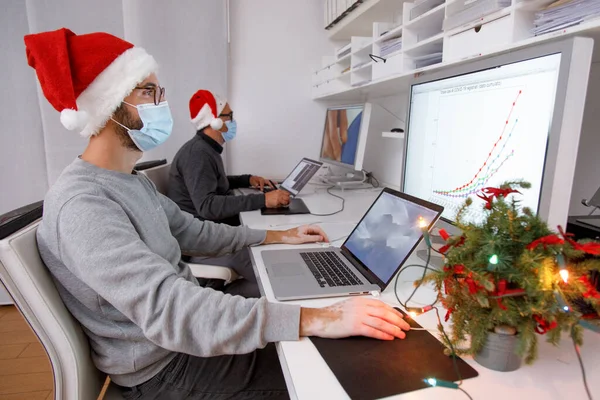 Männer Medizinischen Masken Arbeiten Büro Mit Laptop Weihnachtskonzept Neujahr Coronavirus — Stockfoto