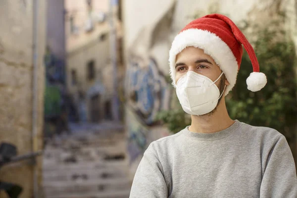 Noel için tıbbi koruyucu maskeli genç adam