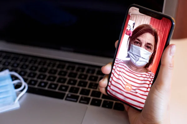 Nainen Joka Käyttää Älypuhelinta Puheluun Puhuu Vanhemman Naisen Kanssa Lääketieteellisessä kuvapankkikuva