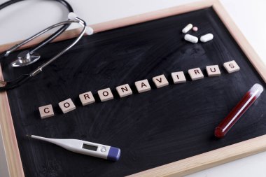 Siyah karatahtanın üzerinde termometre ve haplarla birlikte 'coronavirus' yazıyordu.