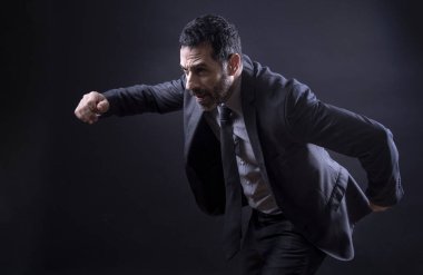 Zarif takım elbiseli yönetici siyah arkaplanda çabucak izole edilir