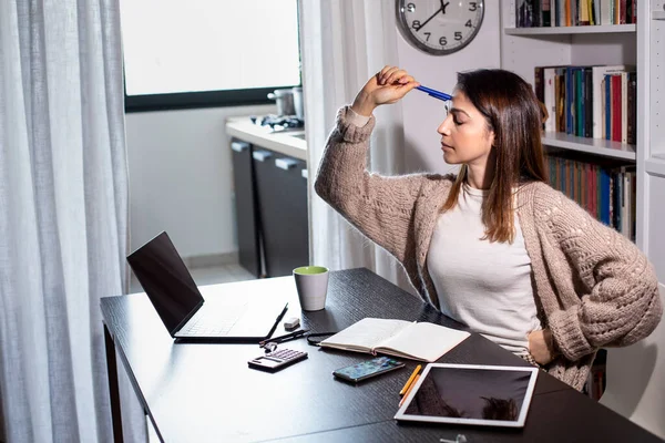 stock image dark-haired girl, practices smart working from home, getting organized in the living room, the kitchen in the background