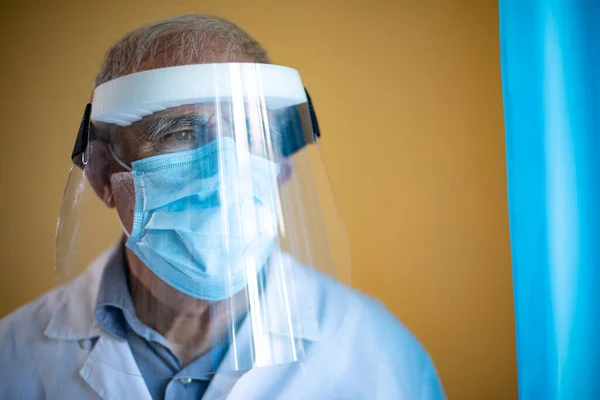 Muotokuva Nuoresta Miehestä Valkoisessa Lääketieteellisessä Naamiossa Sinisessä Puvussa Katsellen Ikkunasta — kuvapankkivalokuva