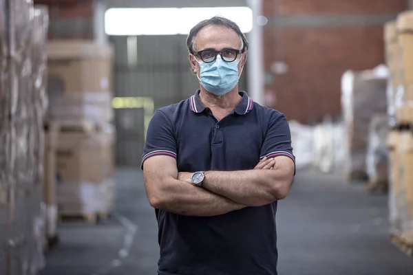 Siyah Gözlüklü Koruyucu Maskeli Bir Adam Çalıştığı Depoda Kollarını Kavuşturuyor — Stok fotoğraf