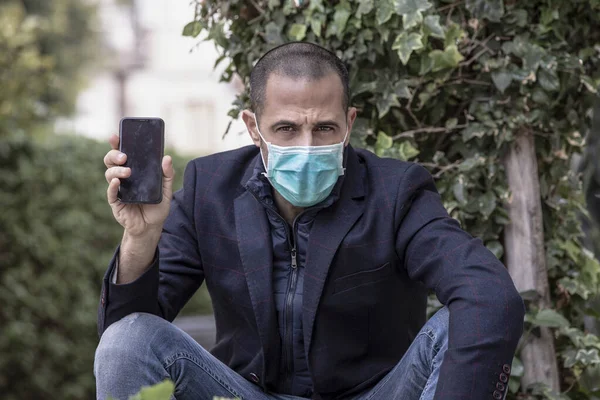 Shaved Man Jacket Wears Protective Mask Shows Screen Black Mobile — Stock Photo, Image