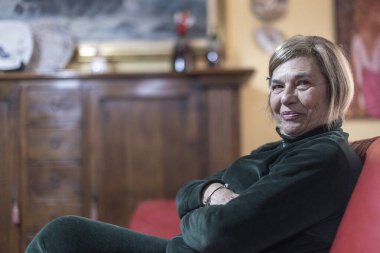 Yaşlı kadın evdeki kanepede dinleniyor. 