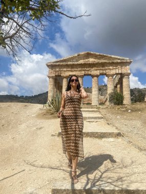 Antik şehrin kalıntılarında yürüyen güzel genç bir kadın.