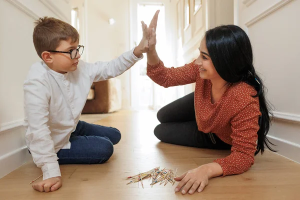 Dark Haired Woman High Fiving Blond Boy While Lying Floor — Stock Photo, Image
