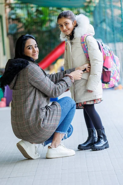 一位母亲陪着女儿上学 在进入学校前给她提建议 调整她的外套 — 图库照片