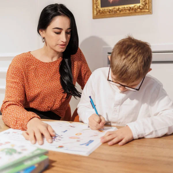 Dark Haired Woman Helps Blond Boy His Homework Sitting Elegant — Stock Photo, Image