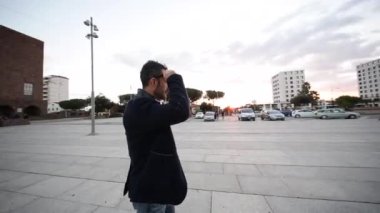 Yakışıklı genç adam şehir merkezinde yürüyor.