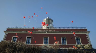 İtalya, Sardinya 'daki Capo Spartivento Oteli' ne karşı havada kırmızı balonlar.