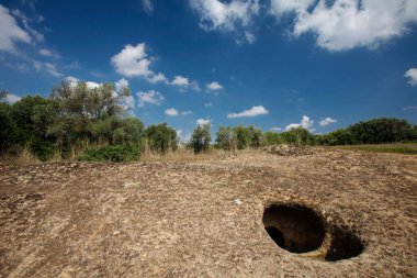 Güneşli bir bahar gününün ortasında ağaçlarla dolu terk edilmiş bir taş ocağı. Bir sürü kum, ağaçlar, çimenler ve mavi gökyüzü