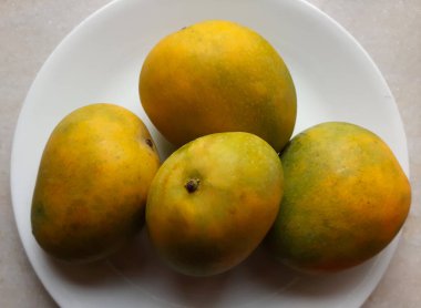 Beyaz plaka arka planında izole edilmiş mango meyvelerinin sarı kralı Alphonso