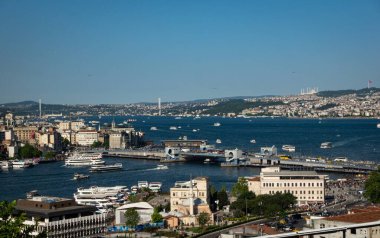 Geniş bir hava manzarası, çeşitli etkileyici binaların etrafa saçıldığı bir su kütlesiyle çevrili güzel bir şehri gözler önüne seriyor.
