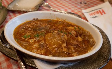 Lezzetli bir çorba tabağı mükemmel bir şekilde bir yemek masasının üzerinde duruyor, birisi tarafından beğenilmeye hazır.