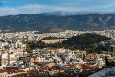 Geniş bir hava manzarası, arka planda muazzam bir şekilde beliren etkileyici dağlarla hareketli bir şehir yakalıyor, hem doğa hem de şehir yaşamını gözler önüne seriyor. Oyunlar.