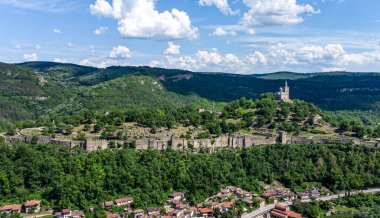 Kuşbakışı bakış açısıyla, görkemli dağların ve etrafındaki yemyeşil ağaçların arasına yerleştirilmiş resim gibi küçük bir kasaba görülebilir.