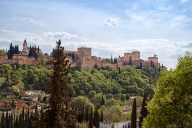 Granada 'da tarihi bir saray olan Alhambra' yı tecrübe edin. Çevrenizdeki canlı doğa tarafından güzelce çerçevelenmiş.