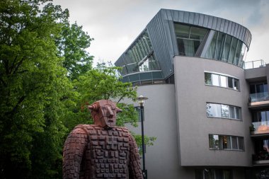 Ostrava 'daki bir robotun paslı metal heykeli. Arkadaki modern bina. Çek malı. Yüksek kalite fotoğraf